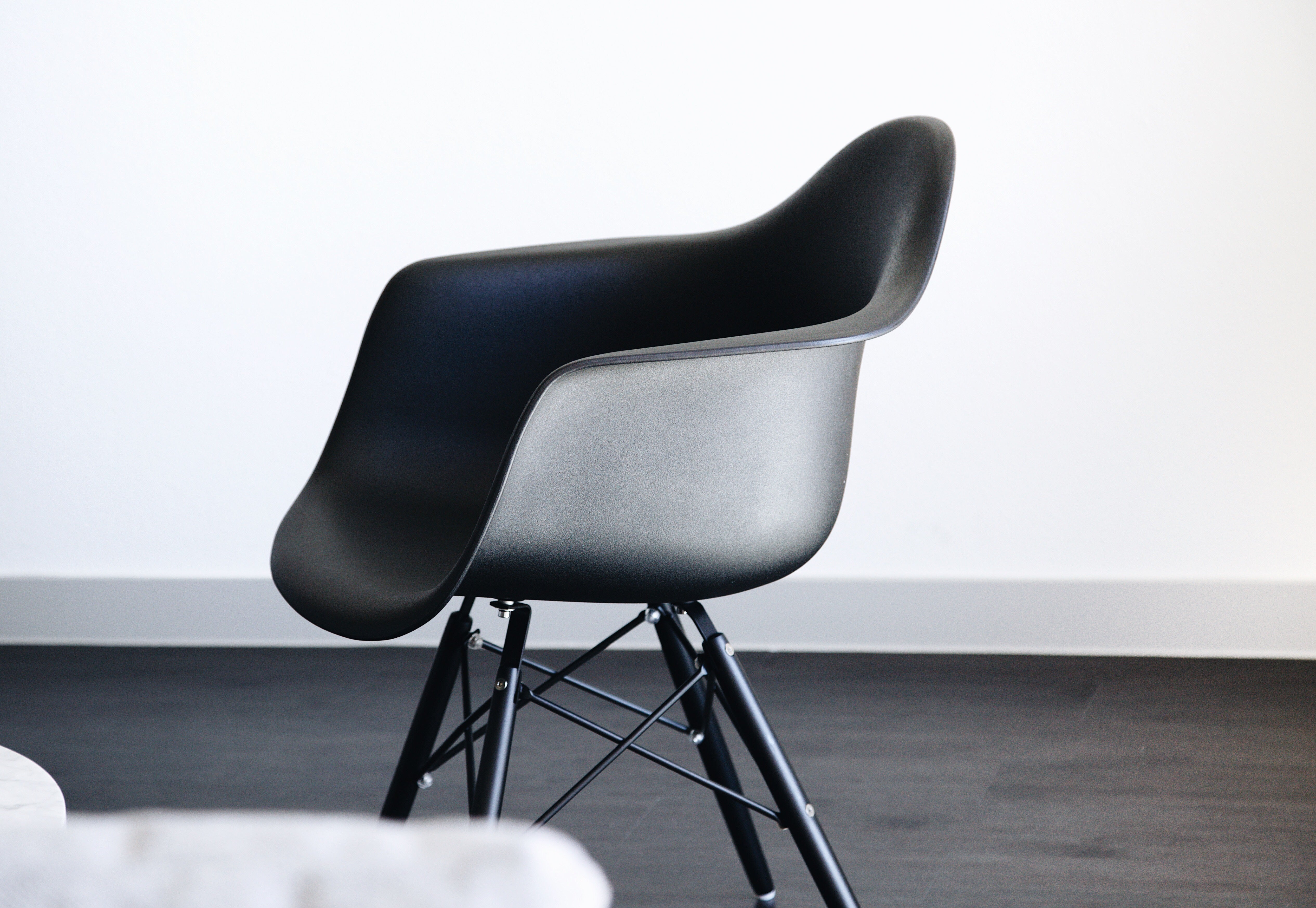 Eames furniture on a black floor and white wall background
