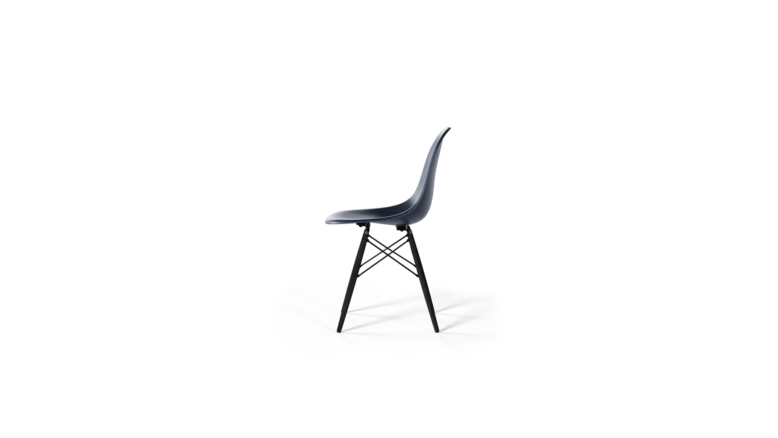 Side-View of the molded Fiberglass Side Chair: Dowel Base DFSW by Charles and Ray Eames, designed by Charles and Ray Eames, available online in Canada. Made by Archetype Forms.