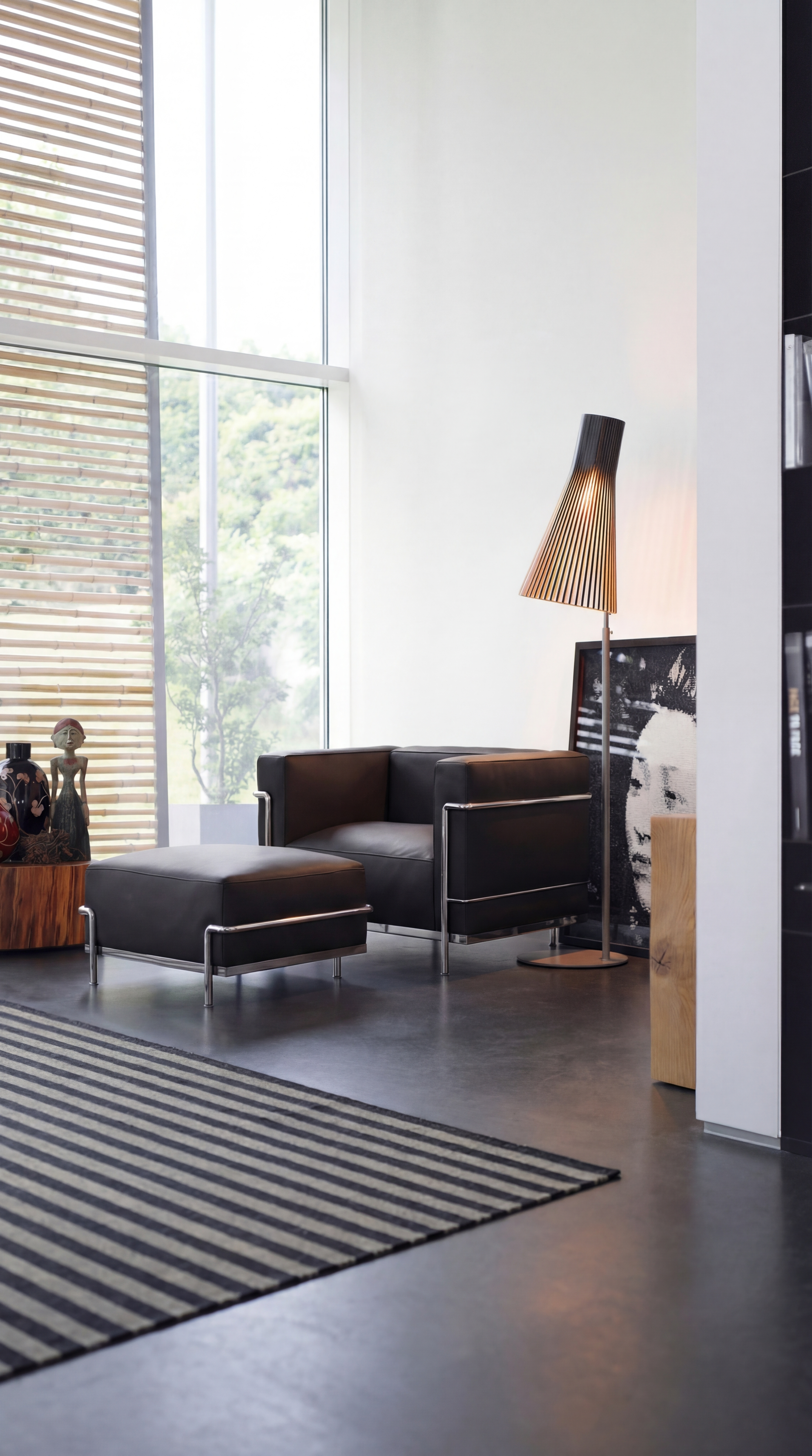 Side angle View of Le Corbusier LC3 Armchair & Ottoman in a modern sitting room, LC3 is the down feather cushion version. Mobile hero image.