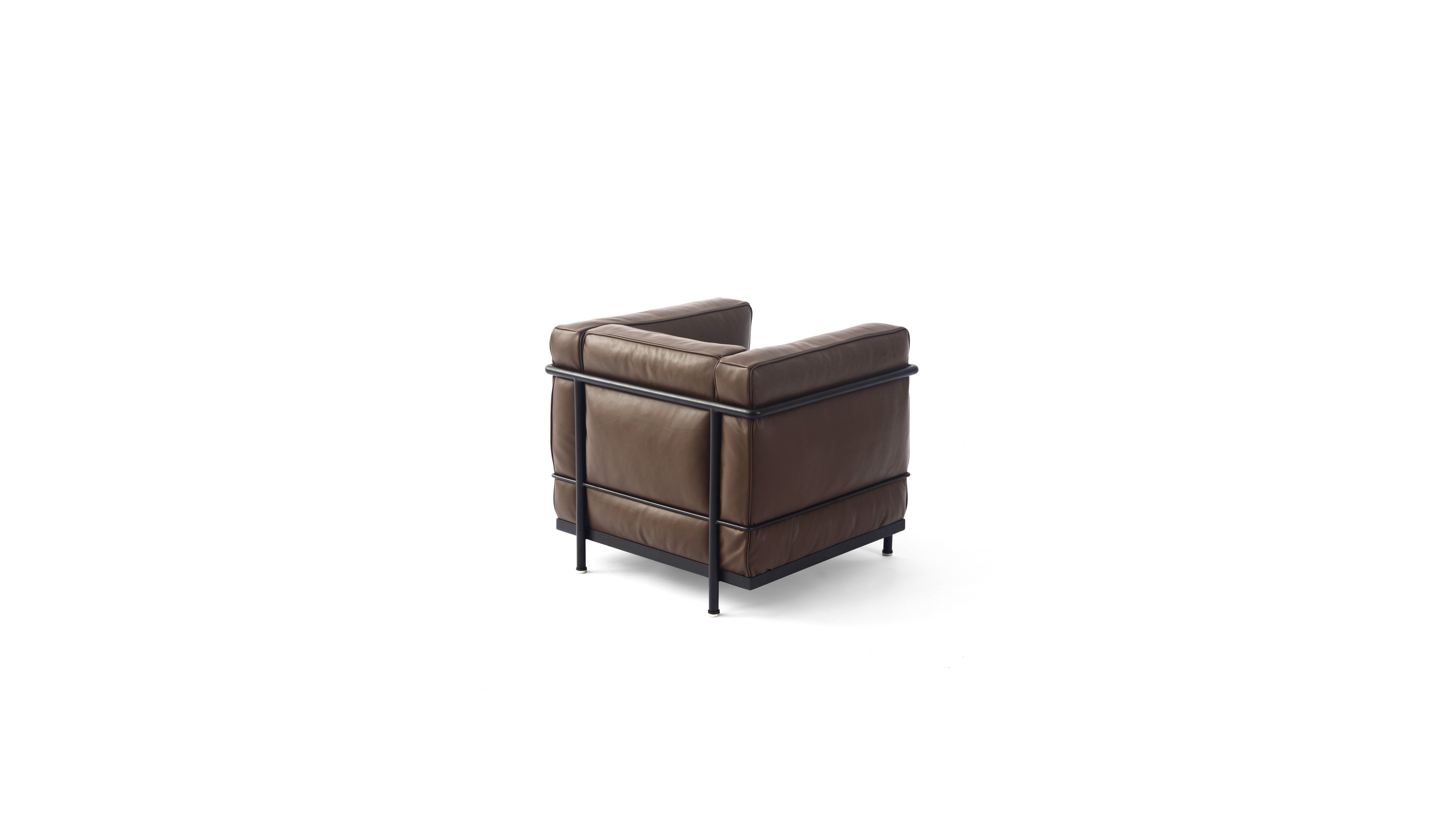 A modern brown leather LC2 armchair with a black metal frame and legs, shown from an upper three-quarter angle on a solid white background.