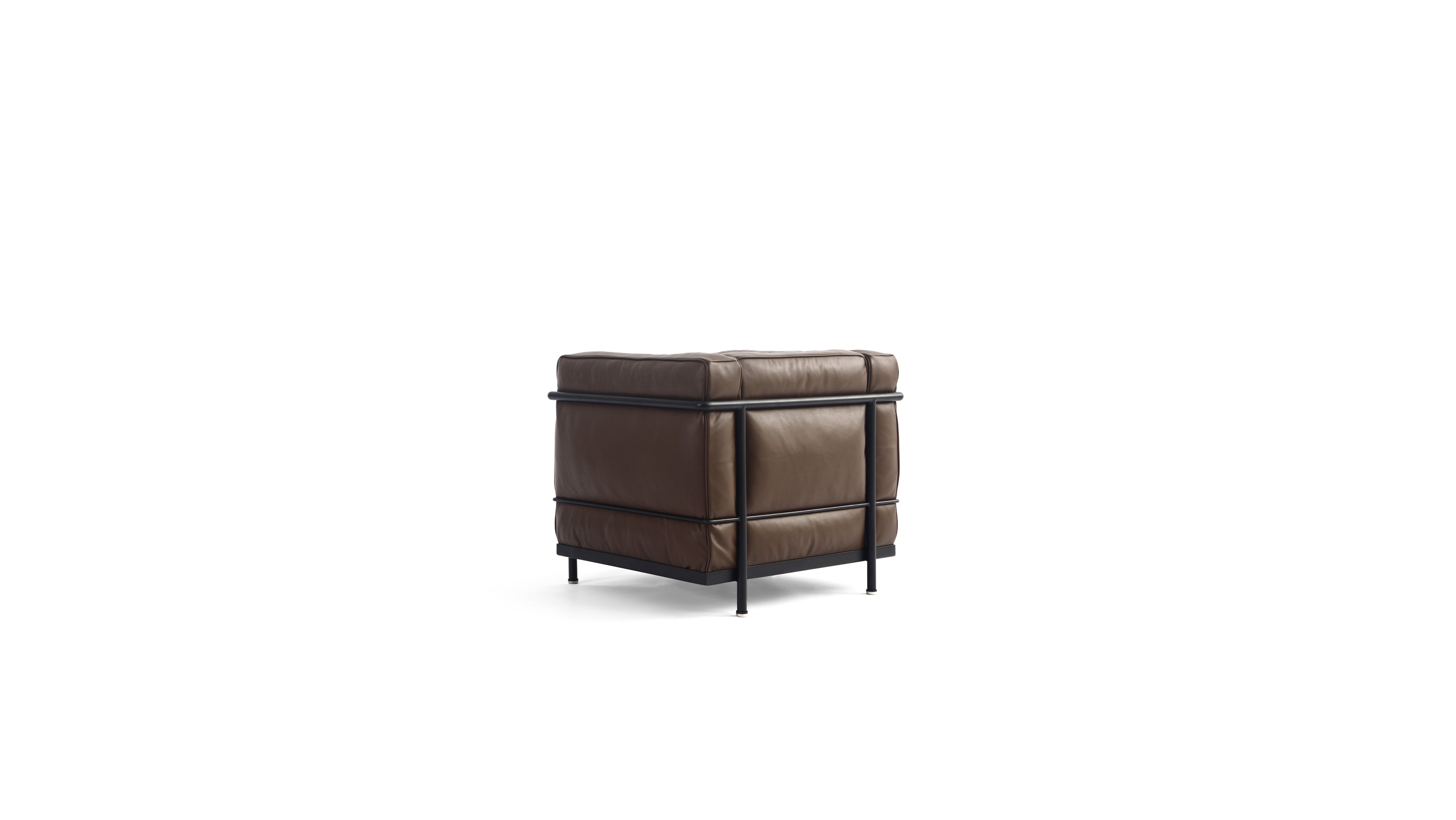 A modern brown leather LC2 armchair with a black metal frame and legs, shown from a three-quarter back angle on a solid white background.