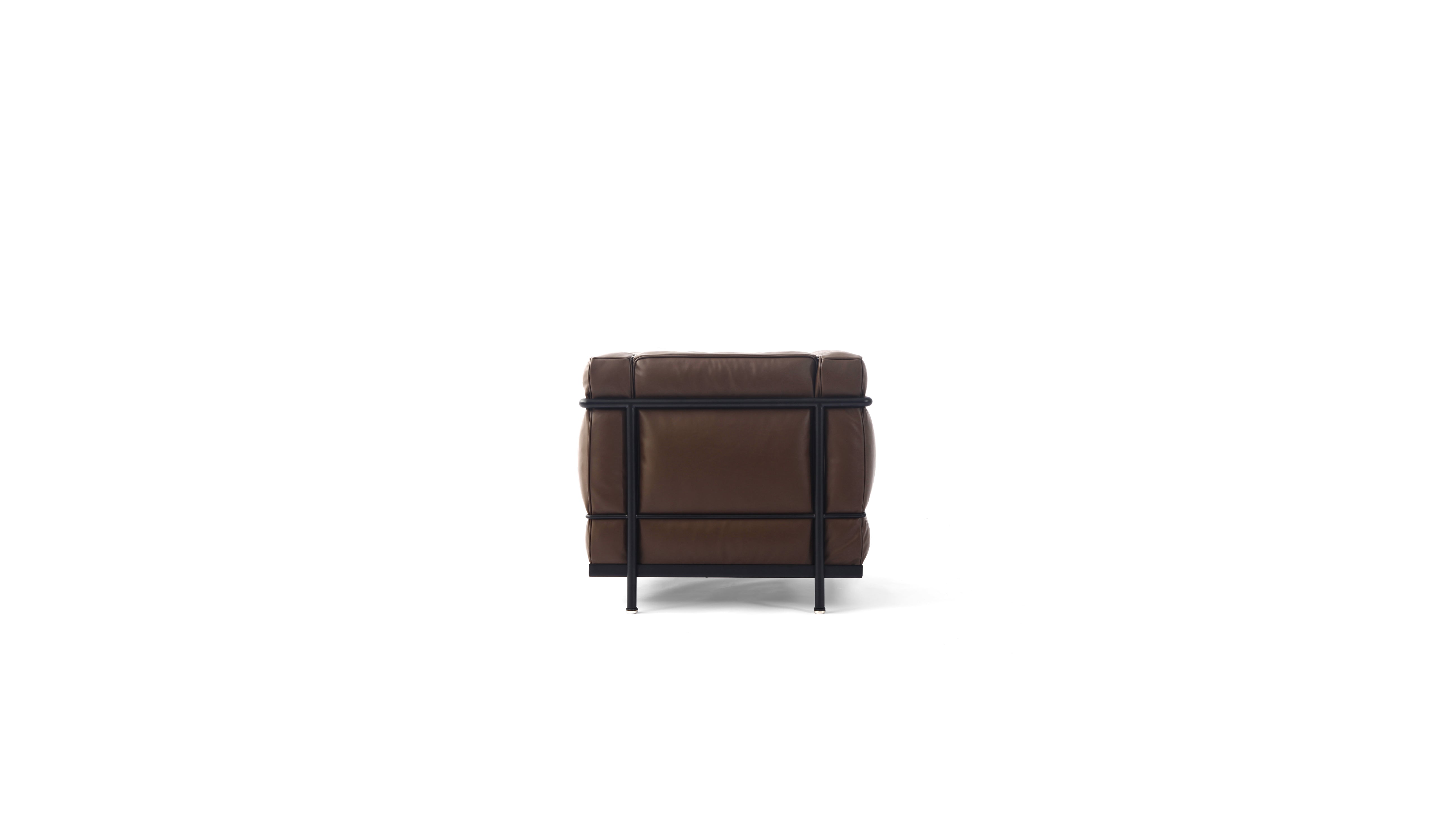 A modern brown leather LC2 armchair with a black metal frame and legs, shown from a back angle on a solid white background.