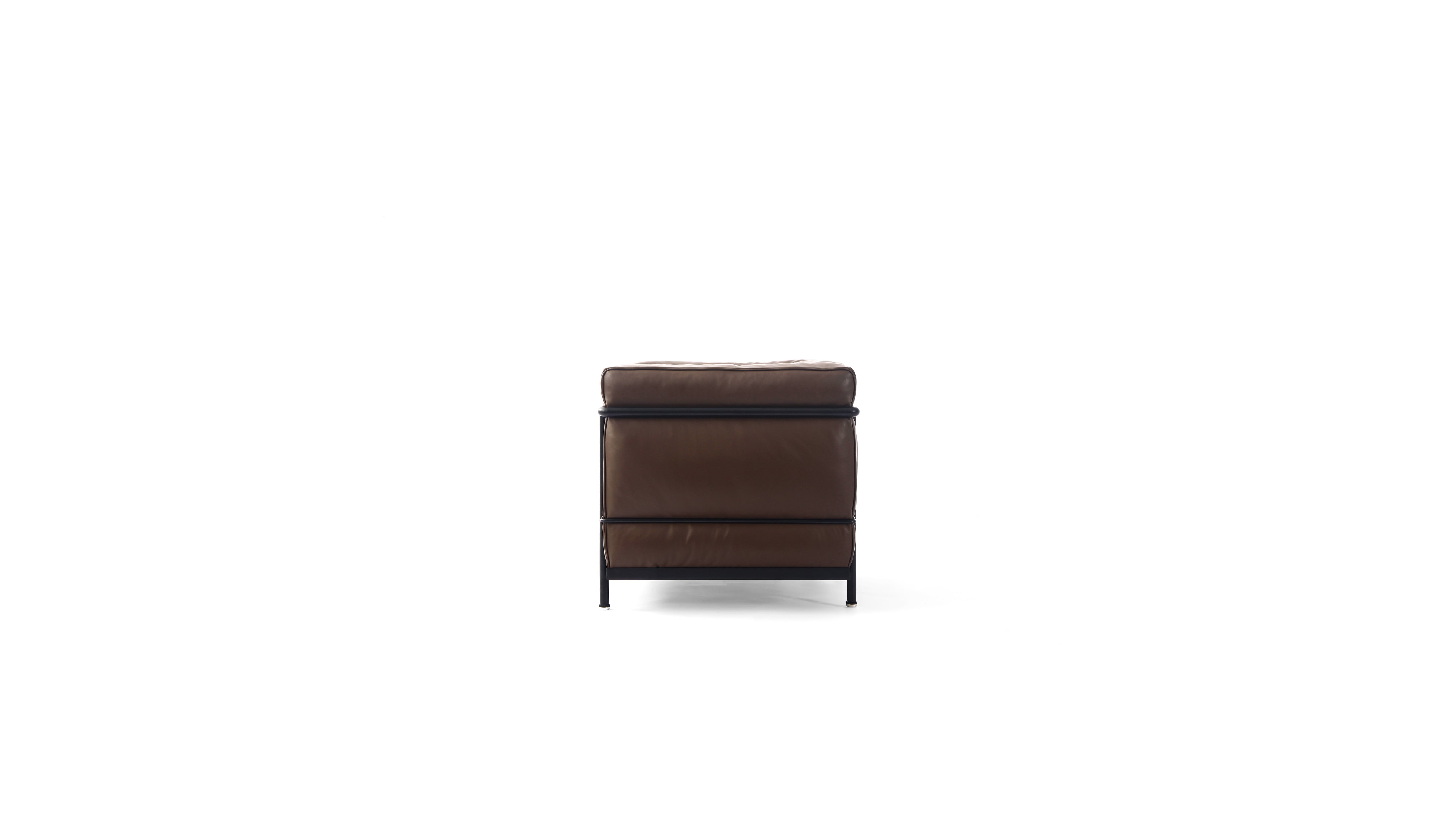A modern brown leather LC2 armchair with a black metal frame and legs, shown from a side angle on a solid white background.