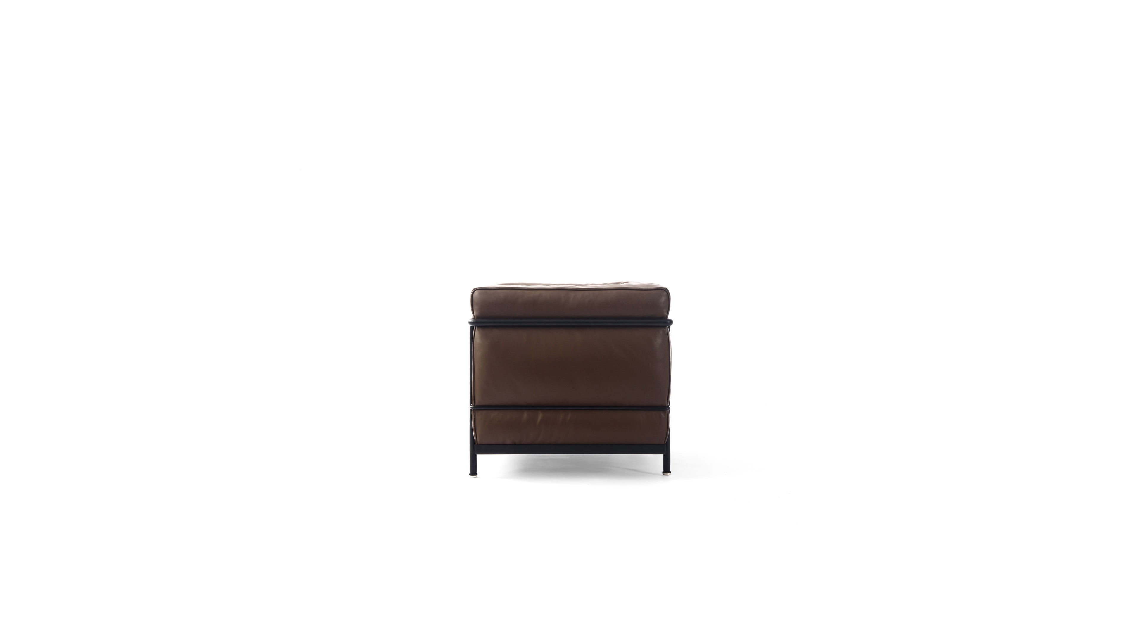 A modern brown leather LC2 armchair with a black metal frame and legs, shown from a side angle on a solid white background.