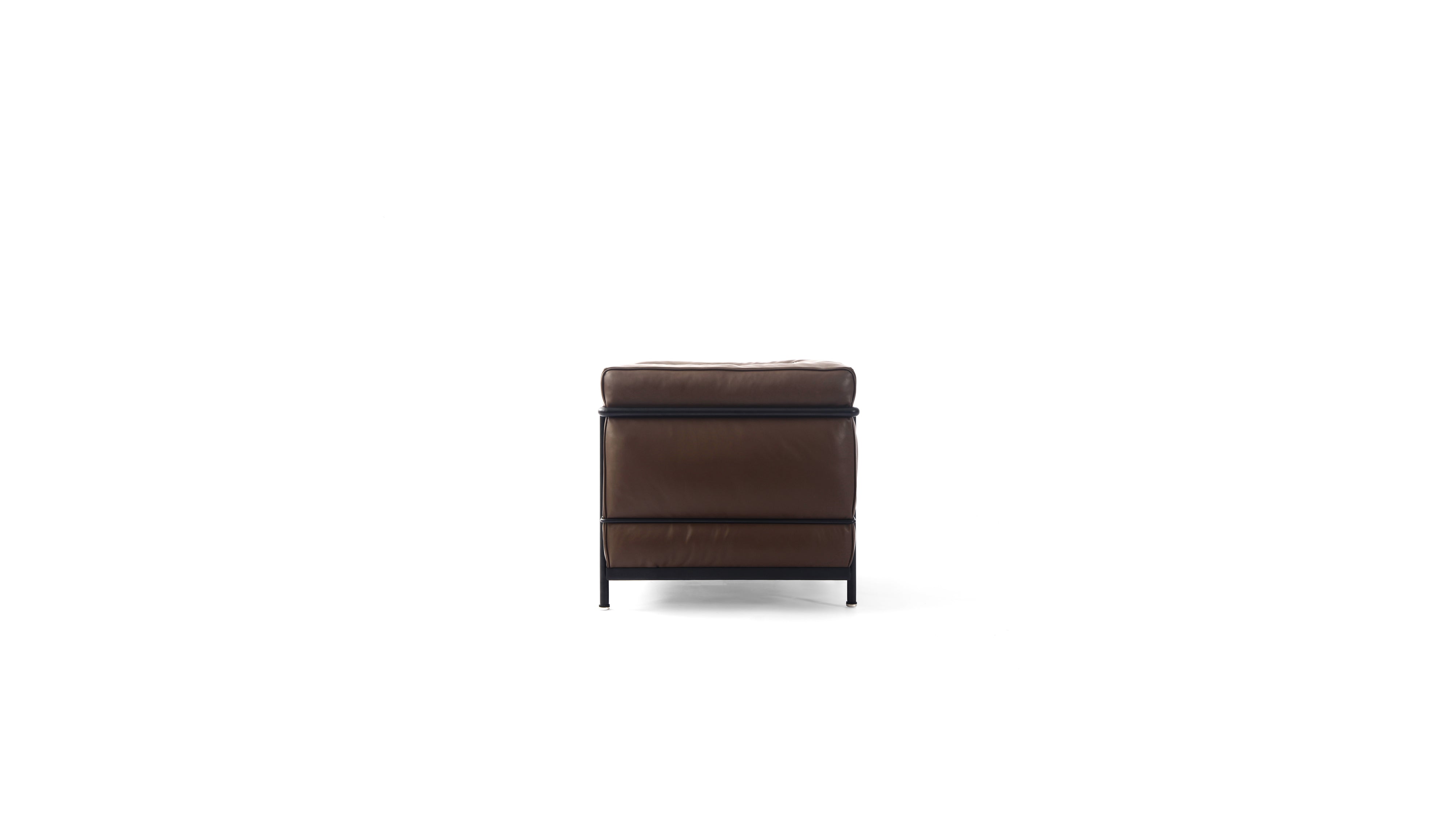 A modern brown leather LC2 armchair with a black metal frame and legs, shown from a side angle on a solid white background.