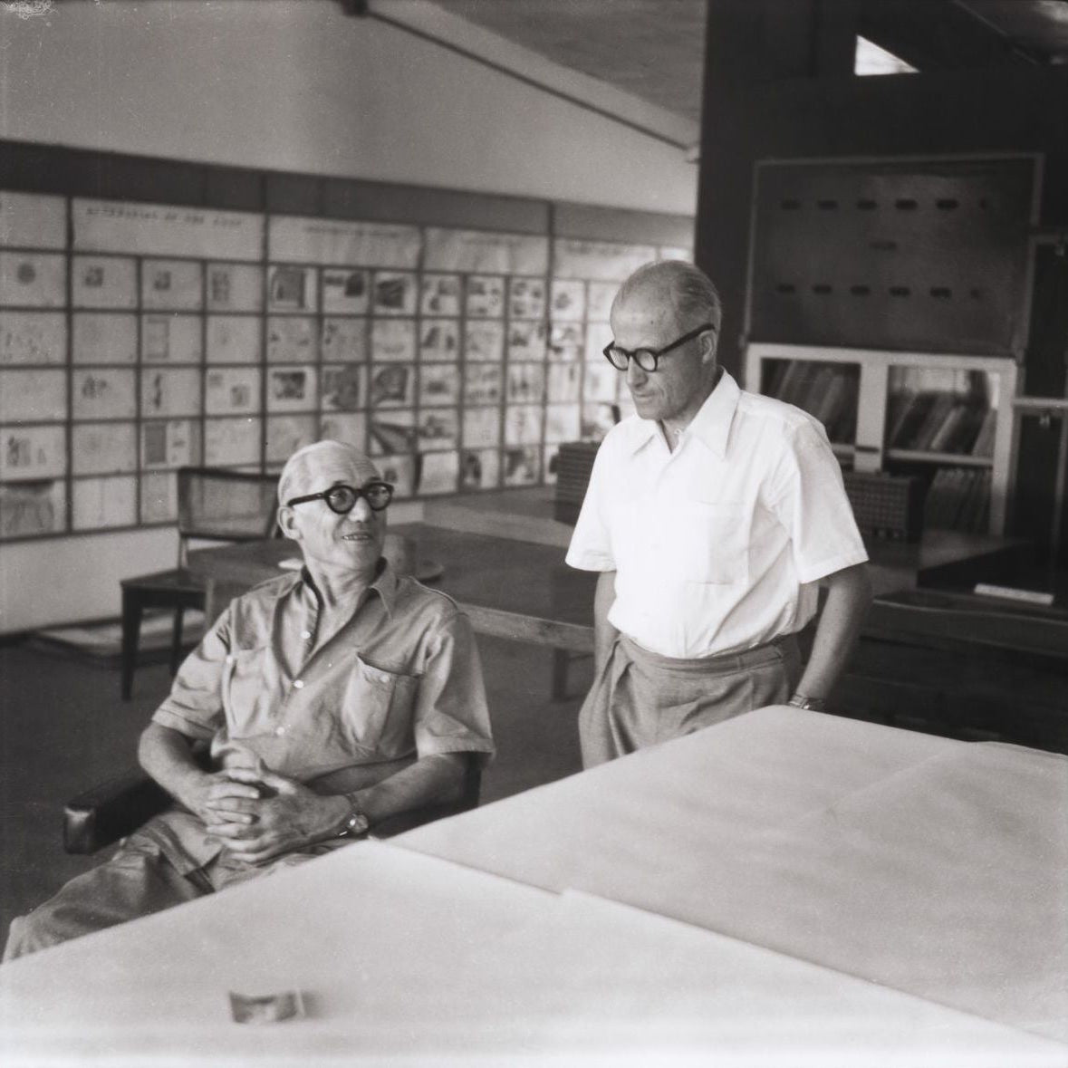 Royalty-free image of Le Corbusier and Pierre Jeanneret in a room with architectural drawings on the wall