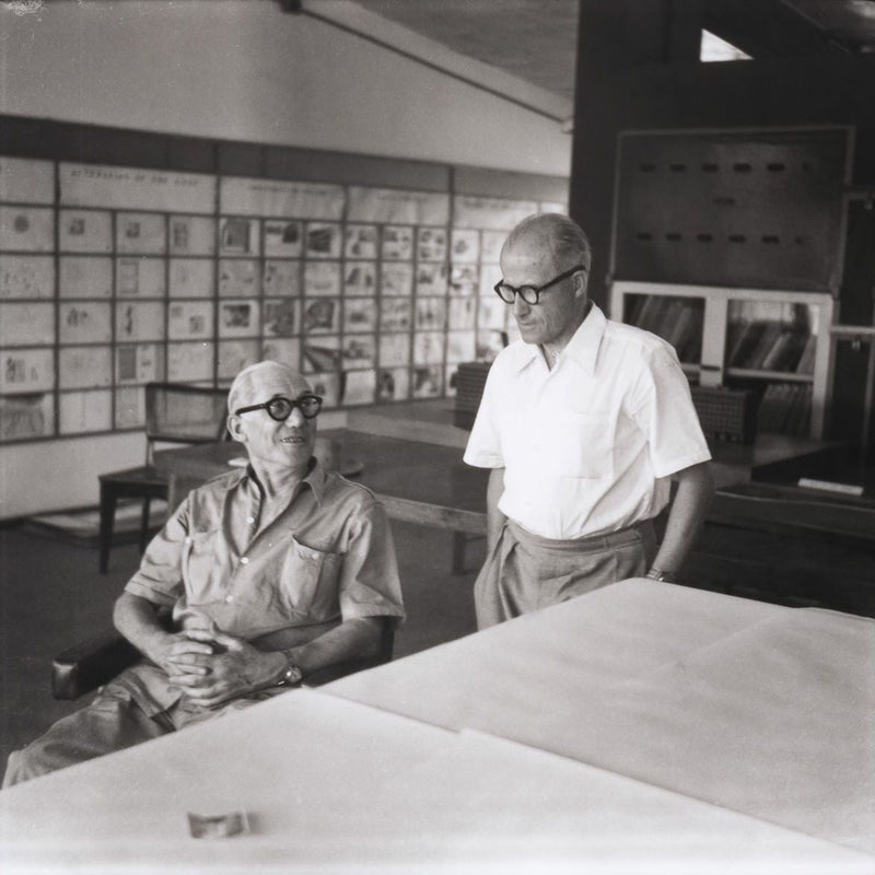 Royalty-free image of Le Corbusier and Pierre Jeanneret in a room with architectural drawings on the wall