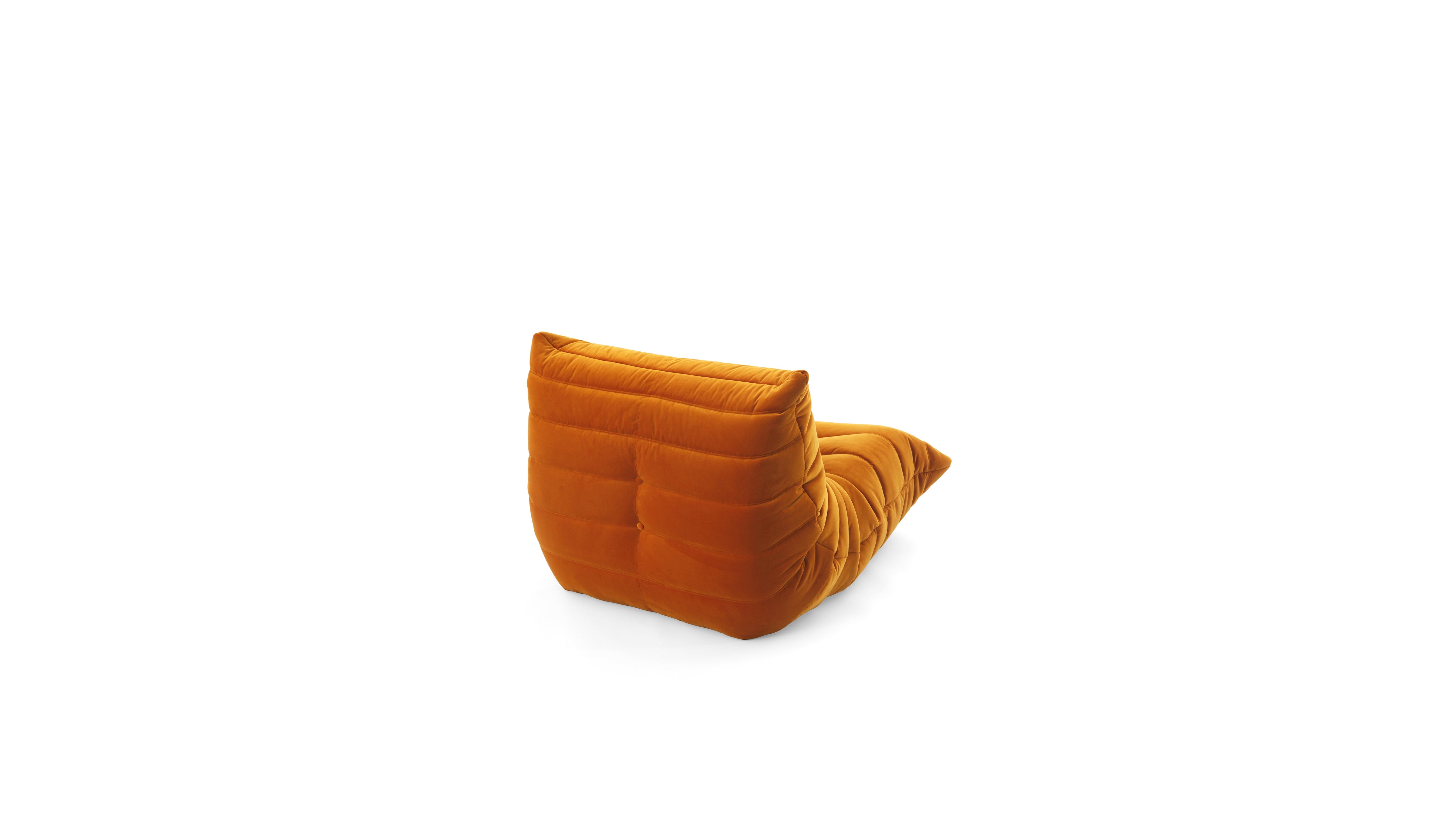 An orange modular upholstered TOGO Fireside lounge chair with a low, thick backrest and a tapered seat, shown from a side angle on a white background.